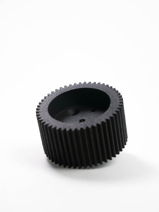 A black plastic gear for a preston DM1x or DM2x motor photographed on a clean white background.