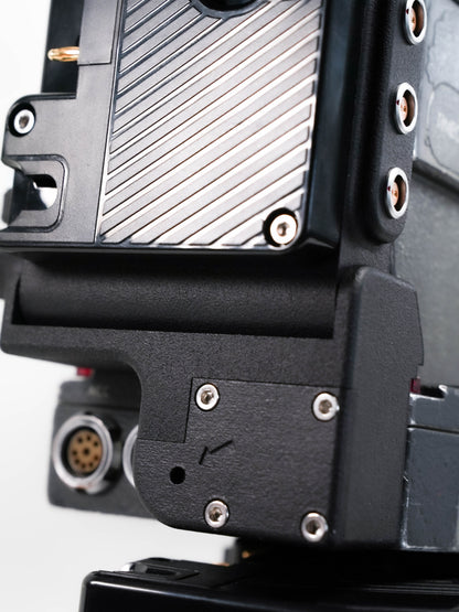 Arri SR3 battery adapter mounted on camera body powering vintage film camera
