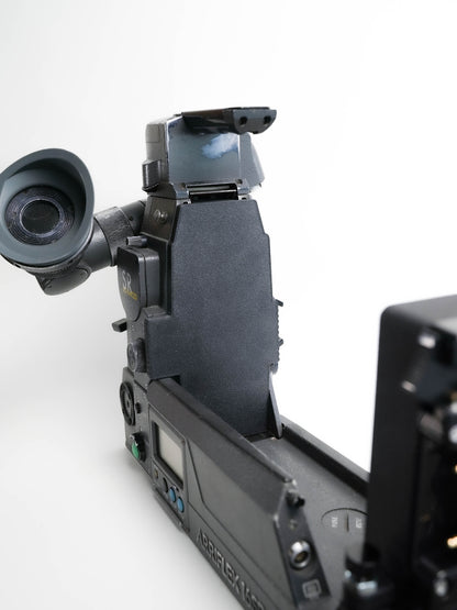 A close-up studio shot of an arri sr sr3 camera body with an attached eyepiece and viewfinder, photographed against a clean white background.