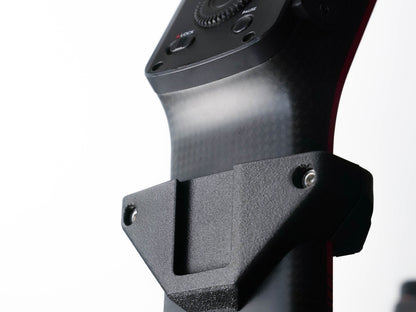 Close-up of a black carbon-fiber-textured camera gimbal handlebar mount with a matte black bracket and mounting screws, set against a clean white background.